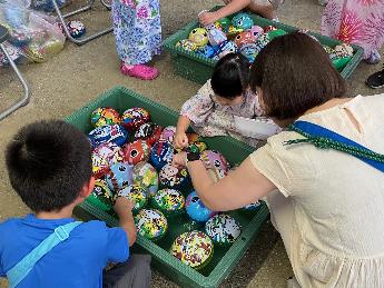 お祭りのスーパーボールすくいを楽しむ様子