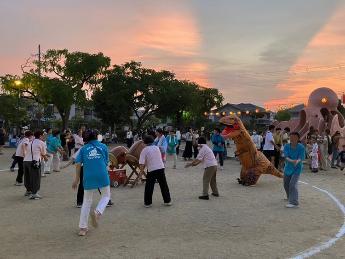 恐竜も一緒に盆踊りを楽しむ様子