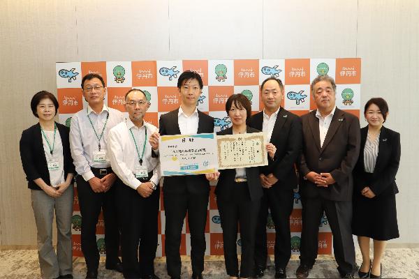 伊丹市からの感謝状を持つ明治安田生命相互保険会社桑山阪神支社長(中央右)と明治安田生命保険相互会社の方々(写真右)と寄付目録を持つ中田市長他(写真左)