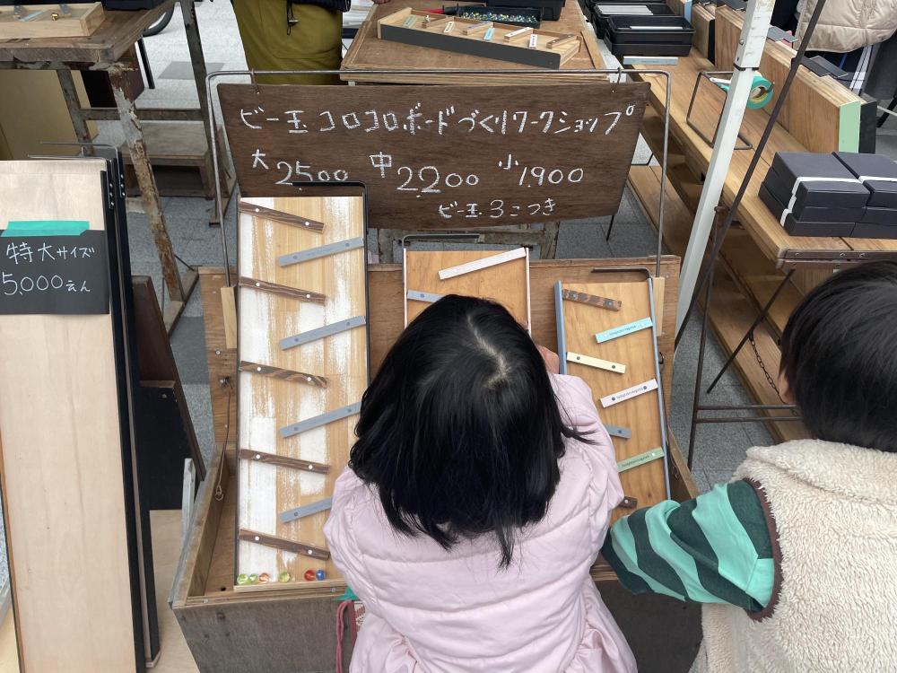 伊丹クリスマスマーケットでビー玉ゲームをする子供