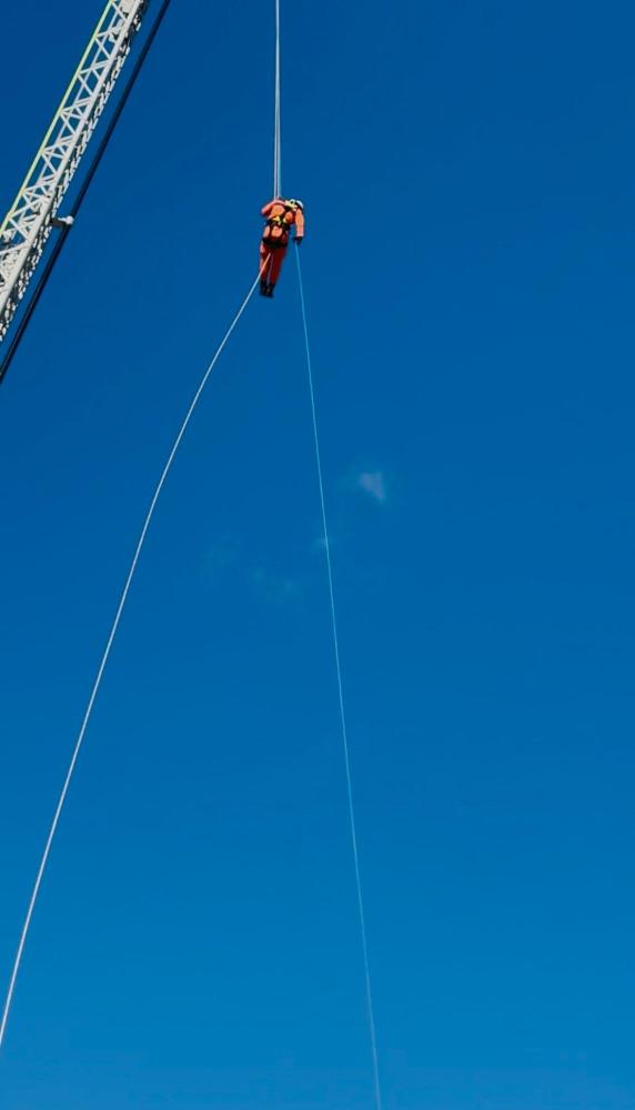 消防出初式ではしご車訓練をする消防職員