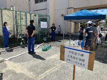 みずほ防災フェア（学校受水槽応急給水について説明を受ける様子）