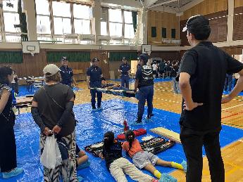 みずほ防災フェア（毛布を使った担架の作り方について説明を受ける様子）