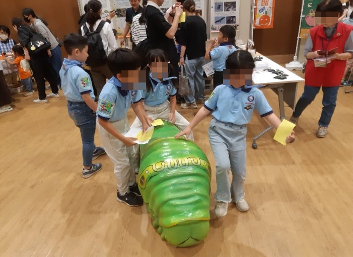 昆虫模型の背中に乗る子供たち