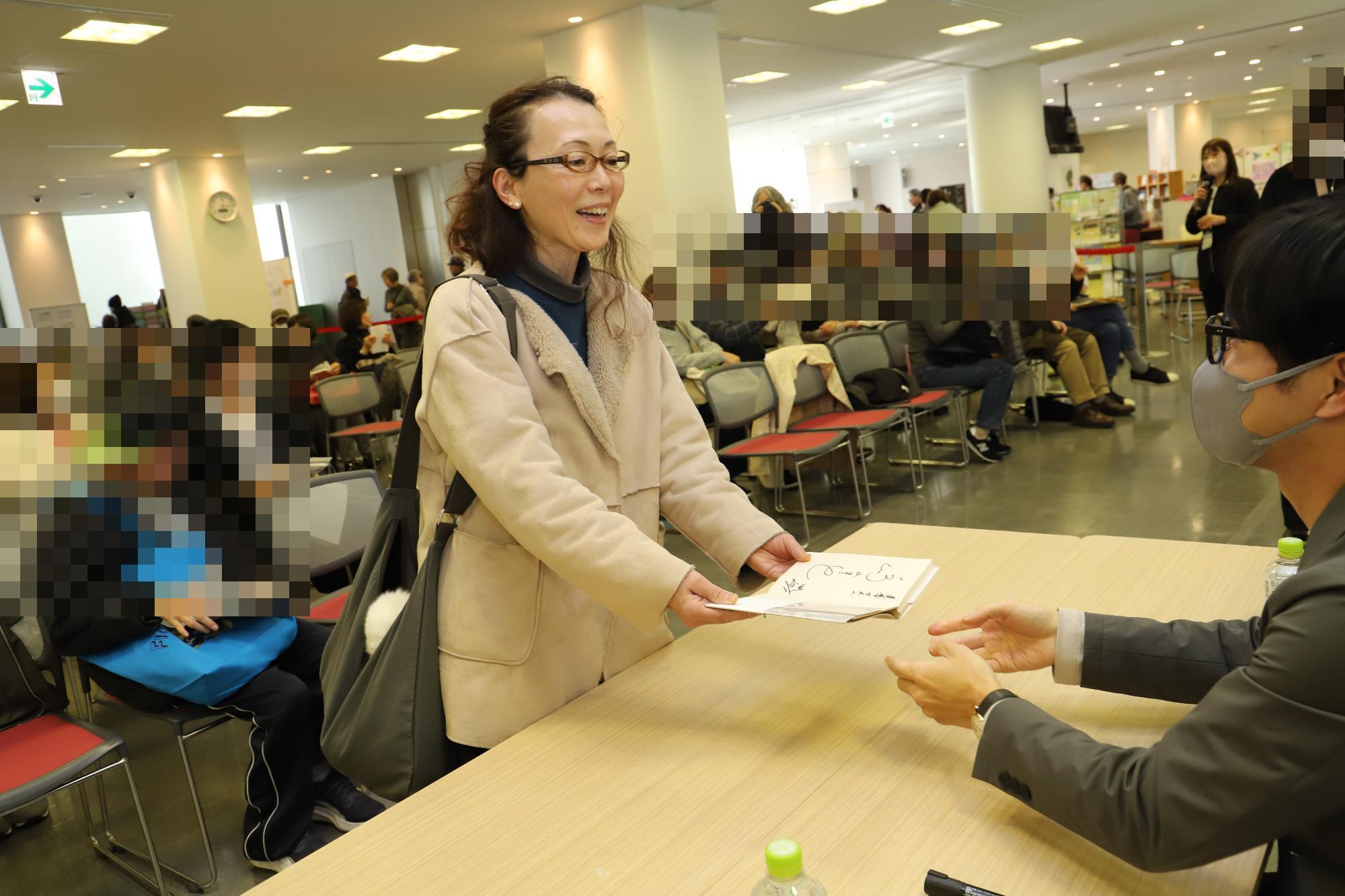 サイン会の参加者へ鳥山さんからサイン本を手渡しているところ