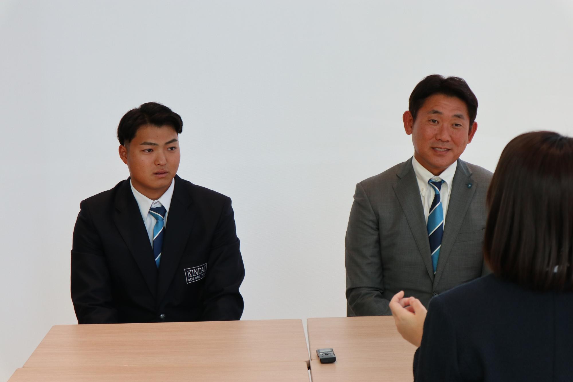 インタビュアーの質問に答える阪上選手と光元監督