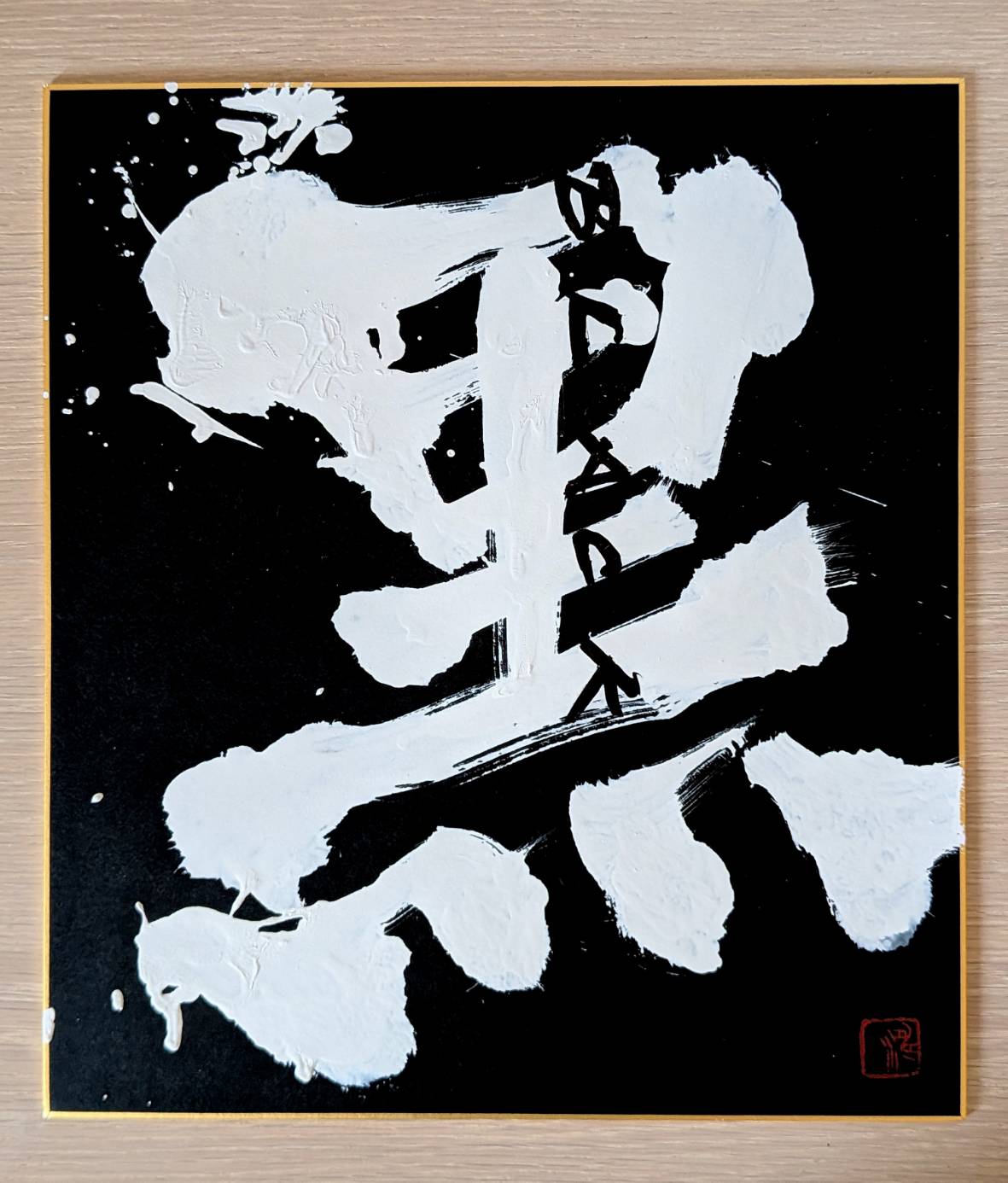 黒い背景の色紙に白い字で「黒」
