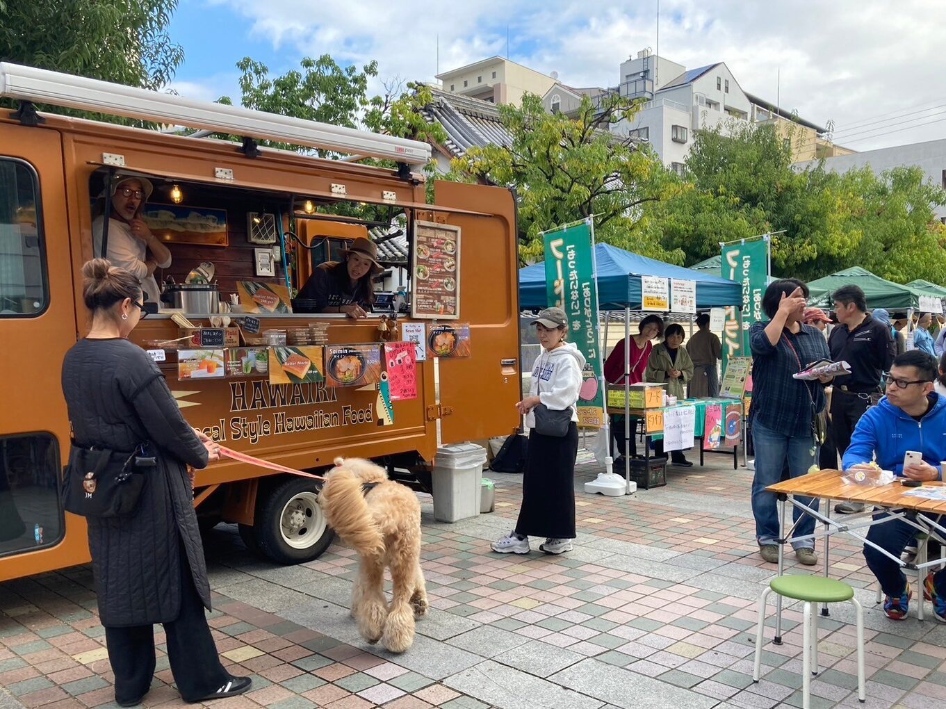 いたみあさまるしぇのおみせのまえでいぬといっしょにあるくじょせい