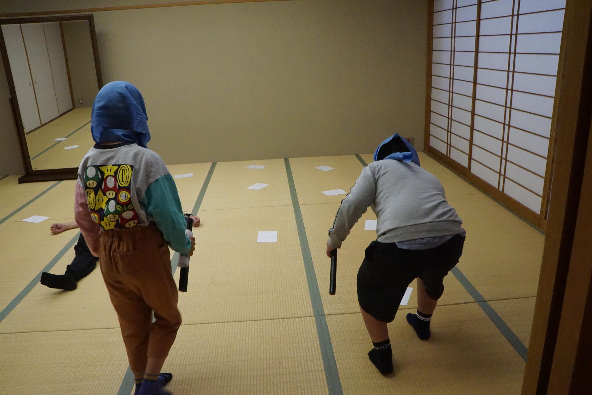 なりきり忍者のイベントでりい忍者のまわりにおいてある紙をそっととる子供