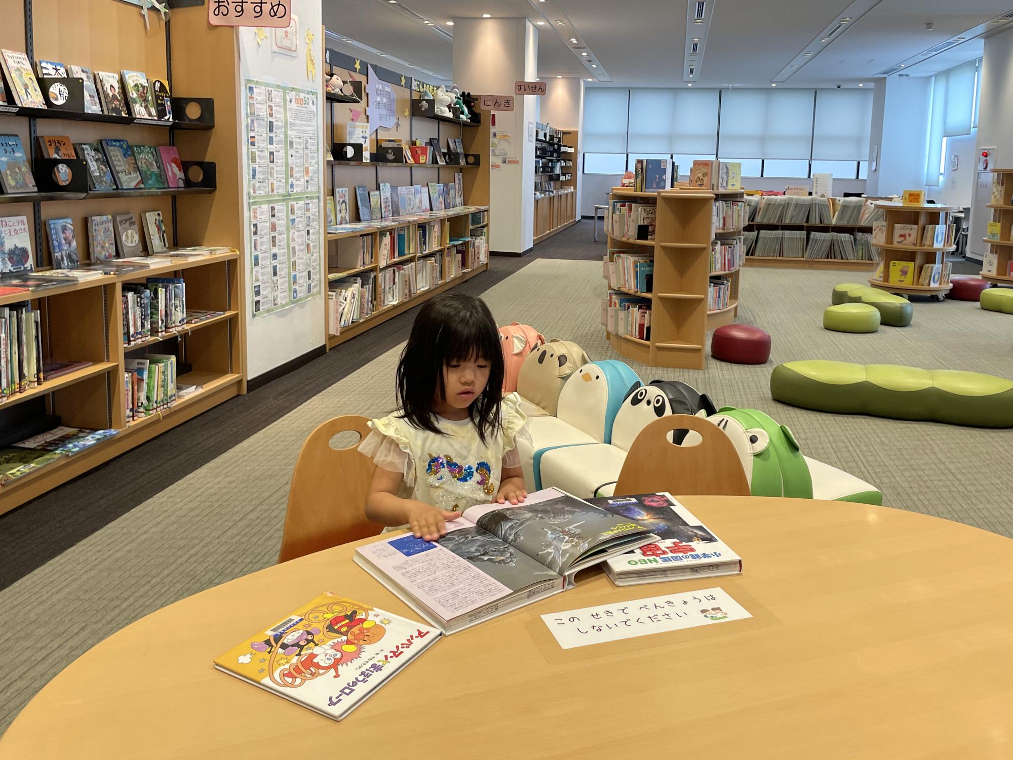 としょかんことばぐらでほんをよむおんなのこ