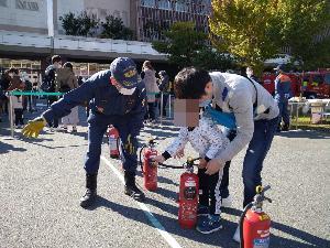 防火イベントで消火器の使用方法を教える団員